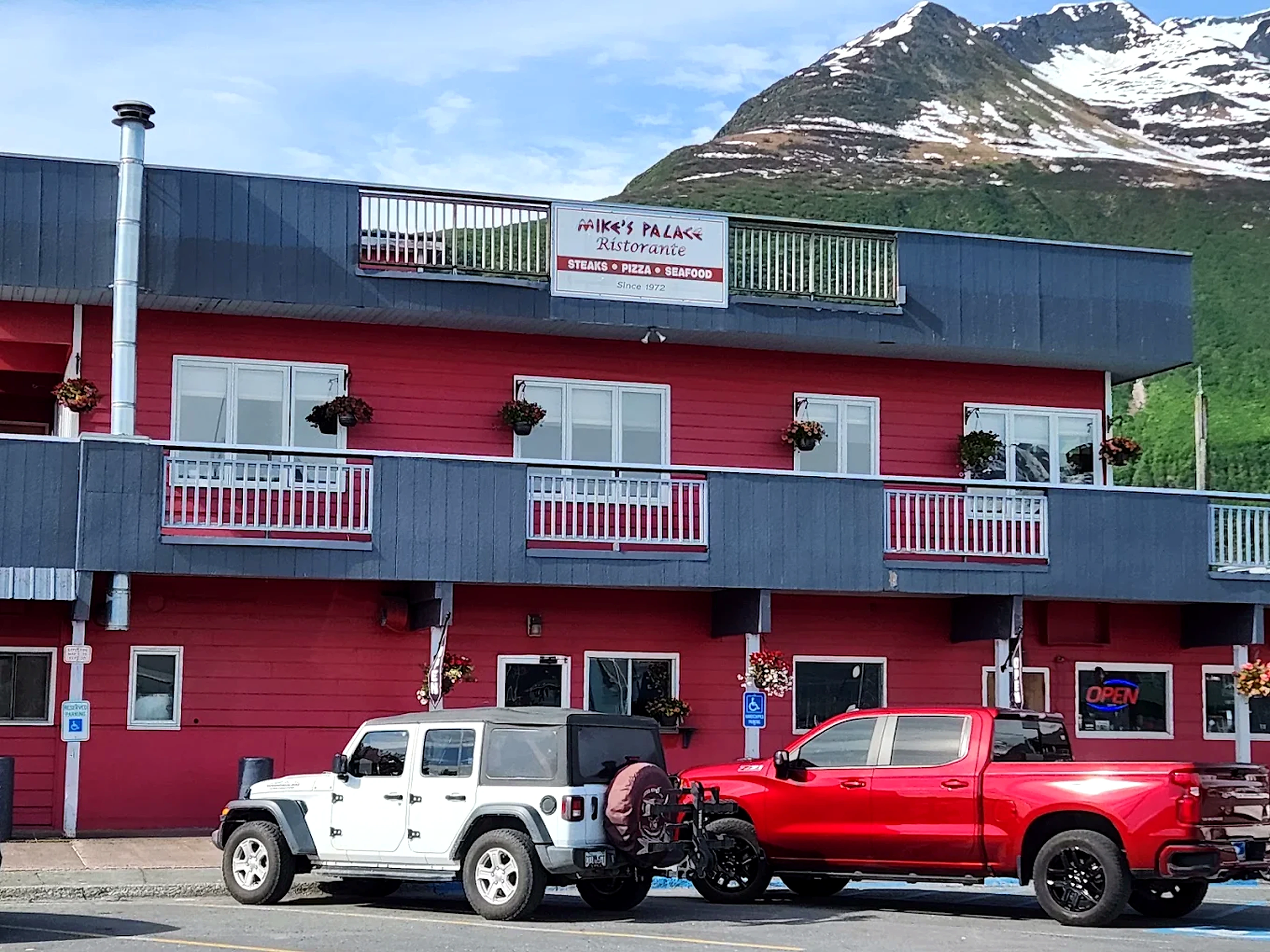 Mike's Palace red storefront beneath Valdez mountains